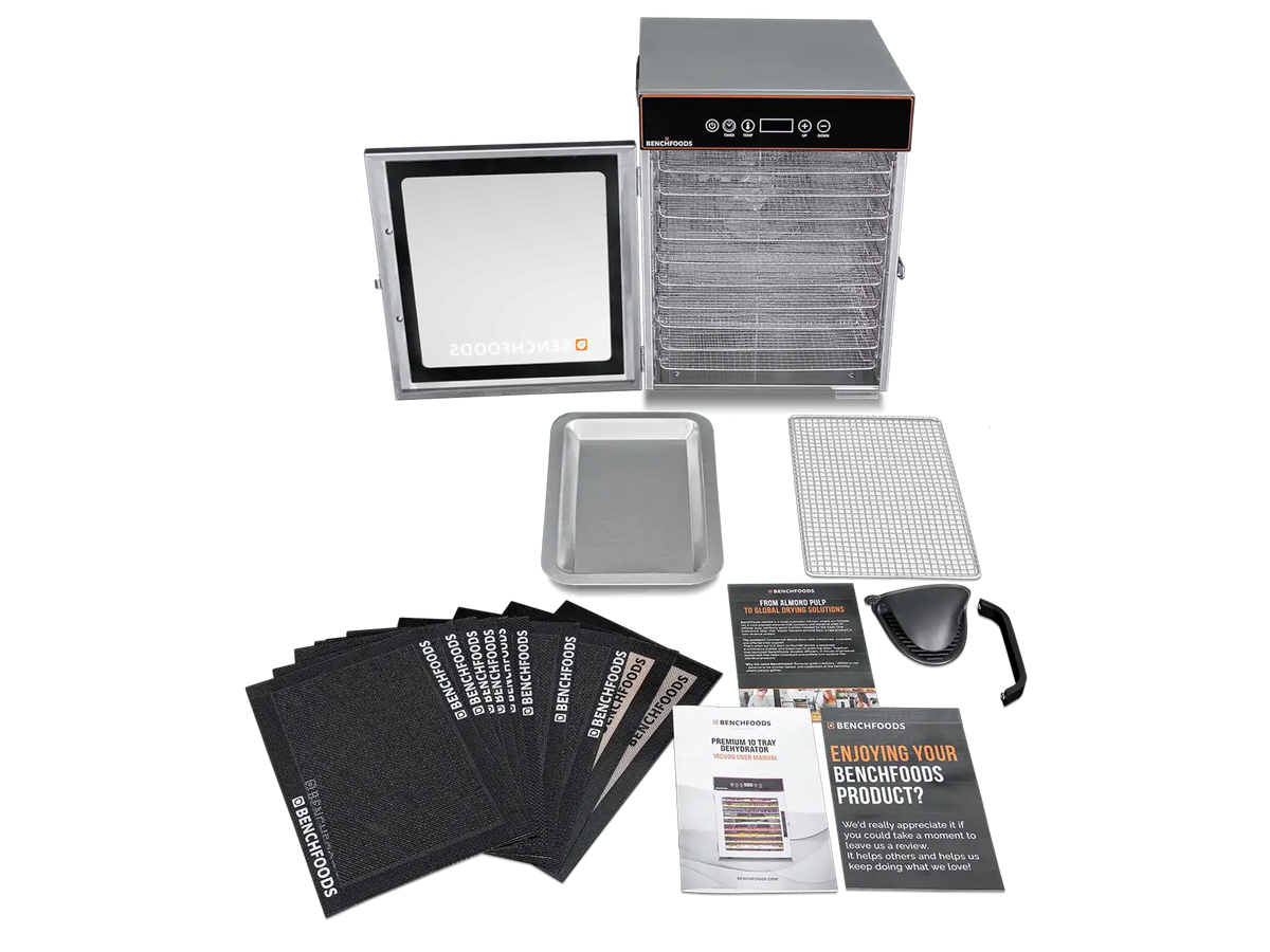 A commercial-grade food dehydrator kit shown on a white background, including the main dehydrator unit with trays, a digital control panel, multiple black dehydrator sheets, a metal tray, a wire rack, a scoop, and instruction manuals.